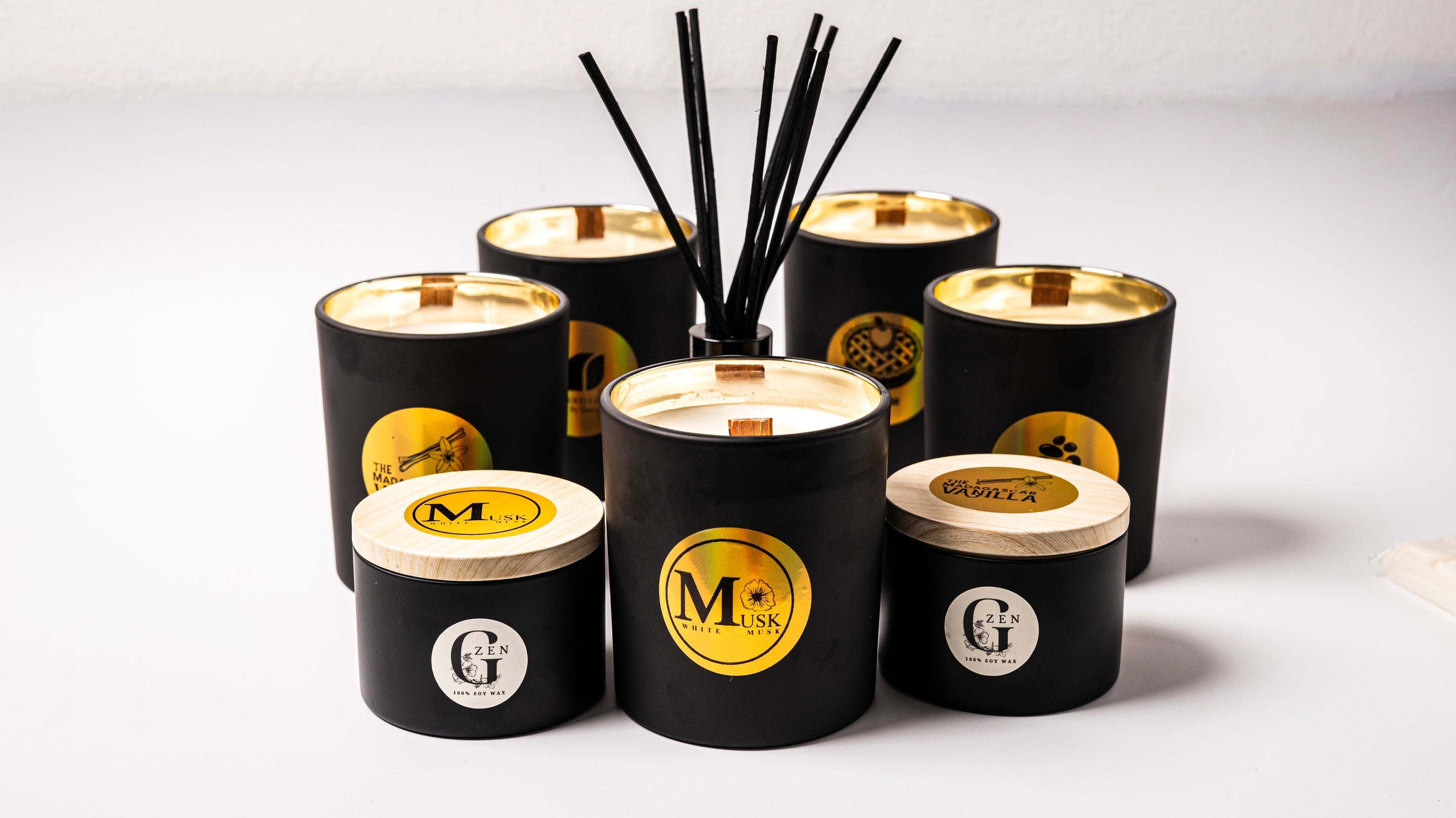 Set of black scented soy candles with wood wick and  gold labels by gzen candles on a white background are  hand poured in cyprus 