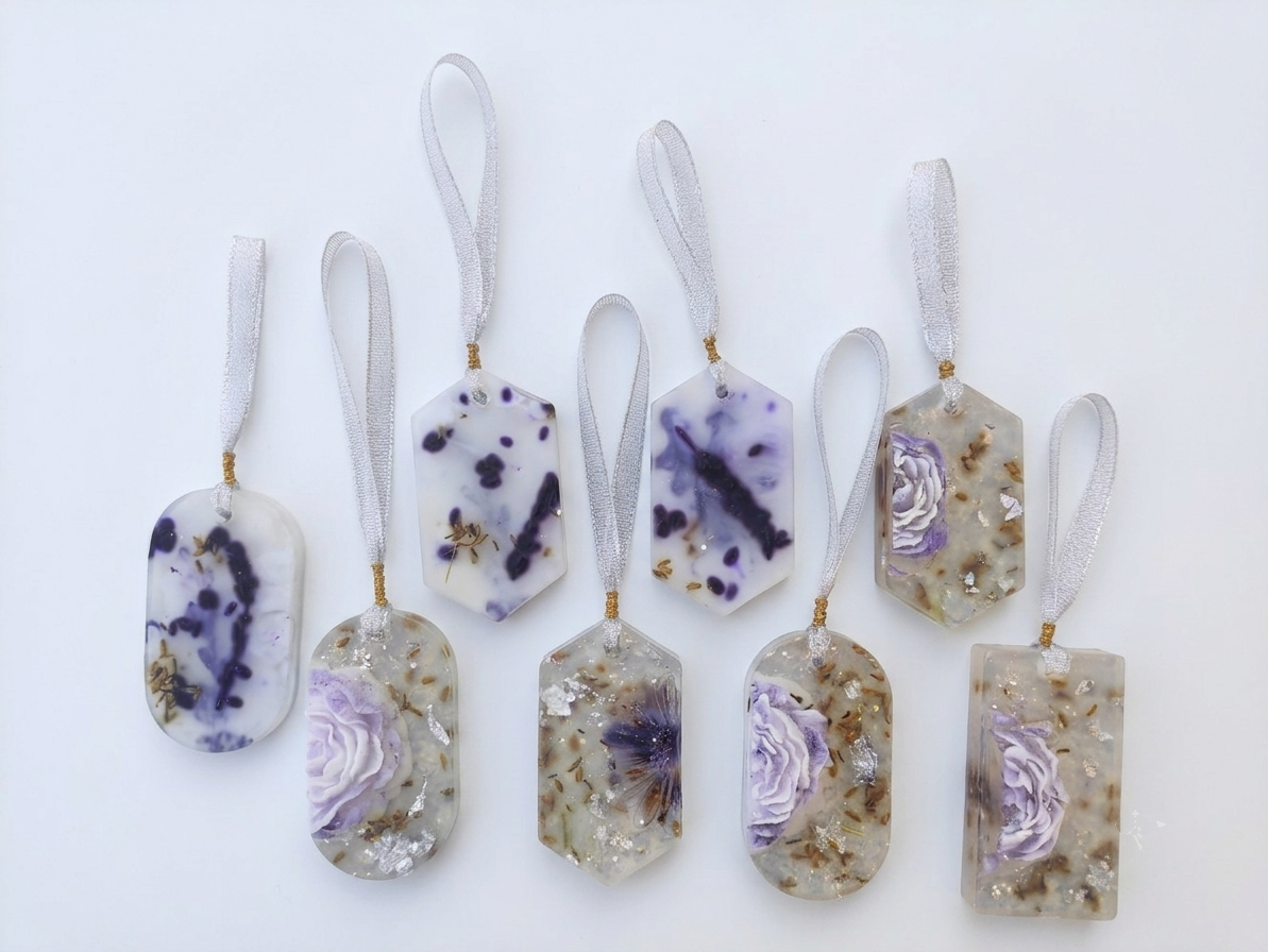 Seven handmade Wardrobe Soap with ribbon loops, featuring purple and beige floral patterns, arranged on a plain white background.