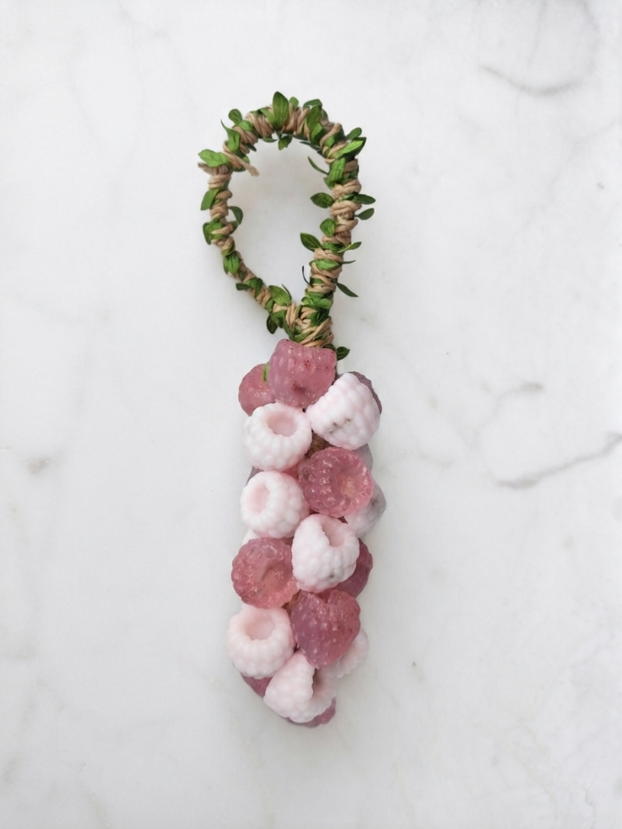 A handmade soap on a rope like bunch of grape or berries shape . Looks like grape 