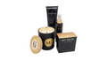 A fragrance gift set by Avgerinos on a white background, featuring a black jar soy scented candle , white musk ,with a bamboo lid and wood wick , a body and hand cream my musk, a black spray oil bottle my musk with gold details, and a black box woman perfume labeled 'MY MUSK'.