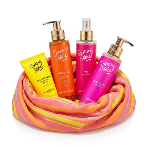 Four Avgerinos Summer Addict Summer Glow self-timer products arranged in a pink, orange, and yellow striped fabric loop on a white background. The set includes a yellow face sunscreen tube, an orange perfect tan bottle, a pink body & hair mist spray bottle, and a pink body glow pump bottle, all with gold caps.