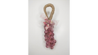 A decorative hanging ornament  handmade soap shaped like a bunch of pinkish-red grapes with a natural jute loop at the top and a sheer pink bow with small floral details, shown against a plain light background.