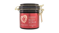 A jar of Avgerinos Cosmetics Hammam Body Scrub with a red label, black lid, and gold metal clasp, shown on a plain white background.