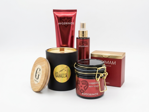 A collection of premium body care products from Avgerinos Cosmetics ,including a black soy scented candle with wood wick and bamboo lid, a red body scrub hammam jar, a red hammam perfume bottle, a red hammam lotion tube, and a red body oil hammam avgerinos, arranged on a white Perfect for gift this gift set is base on Limassol by Gzen candles. You can buy only and ship to Cypand worldwide.