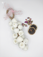 Decorative wreath with white berries soap,dried lemon slices, and purple flowers on a white background