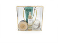 A curated gift set in a clear acrylic box with a gold frame, containing a green Avra body cream tube by avgerinos cosmetics , avra body mist by avgerinos , a round wooden box candle watermelon by gzen candles, and a clear jar of bath bomb watermelon , with rope handles visible against a white background. 