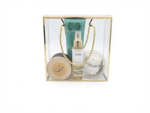 A curated gift set in a clear acrylic box with a gold frame, containing a green Avra body cream tube by avgerinos cosmetics , avra body mist by avgerinos , a round wooden box candle watermelon by gzen candles, and a clear jar of bath bomb watermelon , with rope handles visible against a white background. 