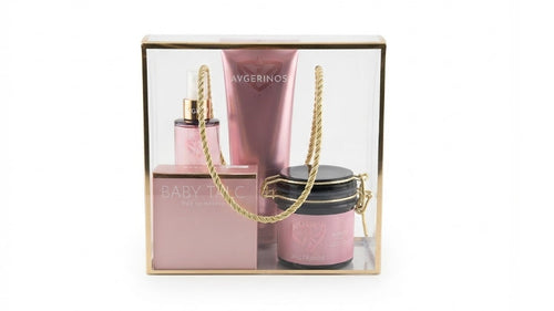 A three-piece baby talc scent gift set by Avgerinos Cosmetics in a clear acrylic box with a gold frame. The set includes a pink perfume bottle, a pink lotion tube, and a pink jar with a gold lid body oil, arranged together with a gold rope handle.