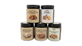 Five glass jars of gourmet baked goods arranged in a pyramid stack on a white background. The top row features two jars: 'Freshly Baked Melomakrona at Grandma's' and 'Ghen Pumpkin'.