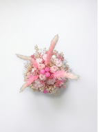 A dried floral arrangement with scented soy wax flowers ,featuring pink and white flowers with fluffy beige pampas grass, photographed from directly above on a clean white background.