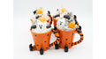Four Halloween-themed ceramic mugs shaped like Tigger's legs, filled with whipped candle cream, chocolate chips, ghost decorations, and orange pumpkin toppers, set against a plain white background. Scented soy candle 