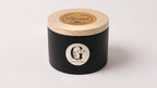 Black candle jar with wooden lid on a white background